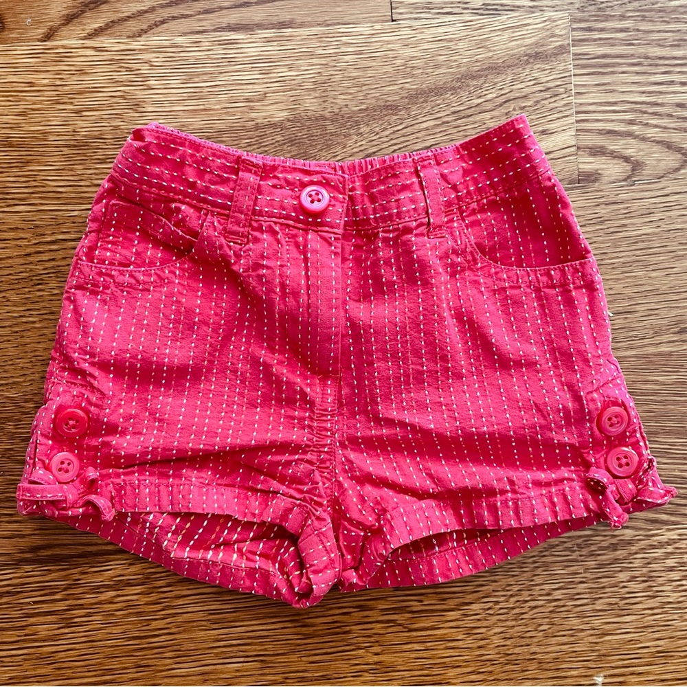 Red shorts with white, yellow and orange pin stripe threads.